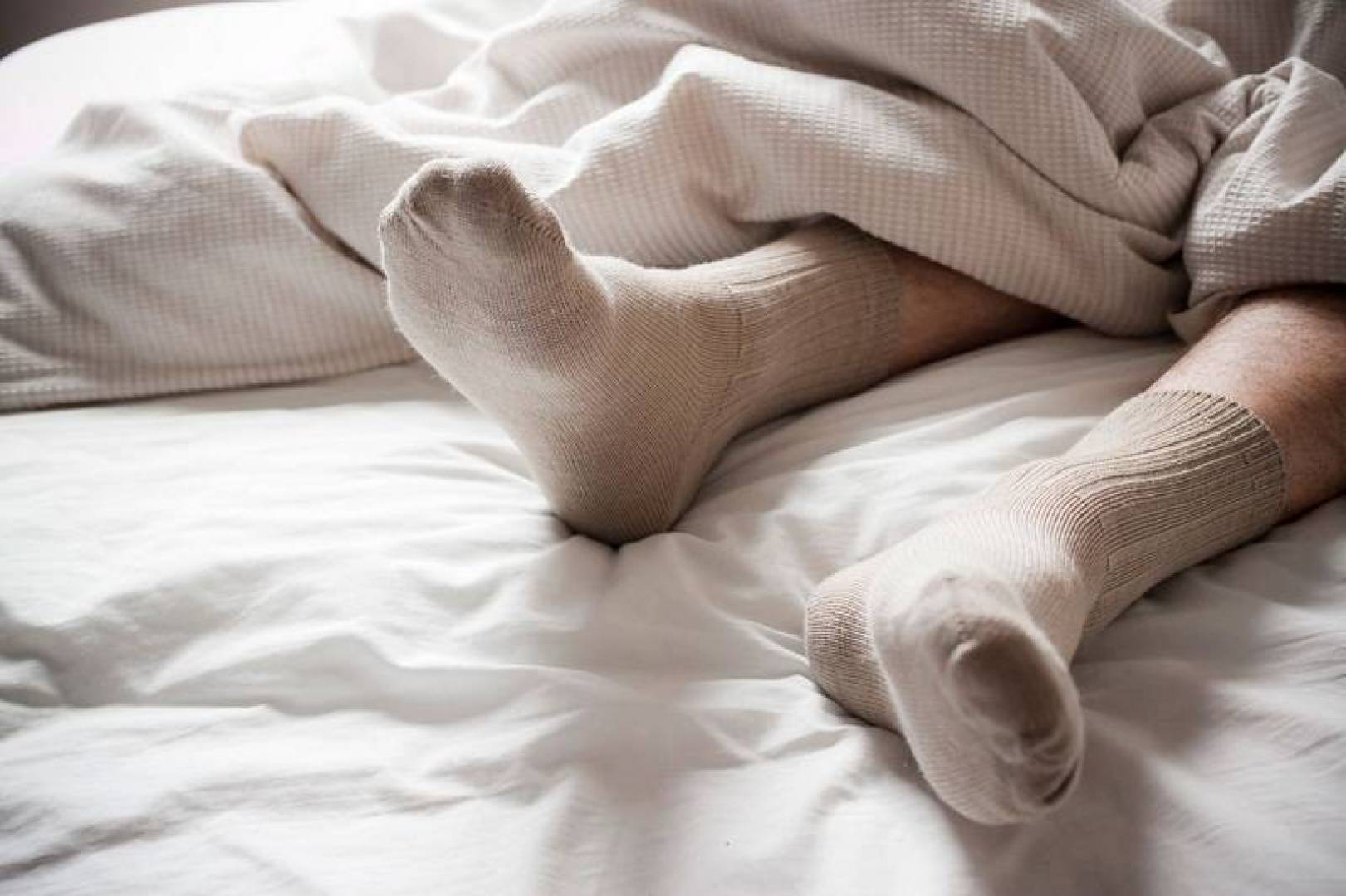 Почему засыпает нога. Ноги в носках. Спать в носках. Ноги в носках на кровати. В носках под одеялом.