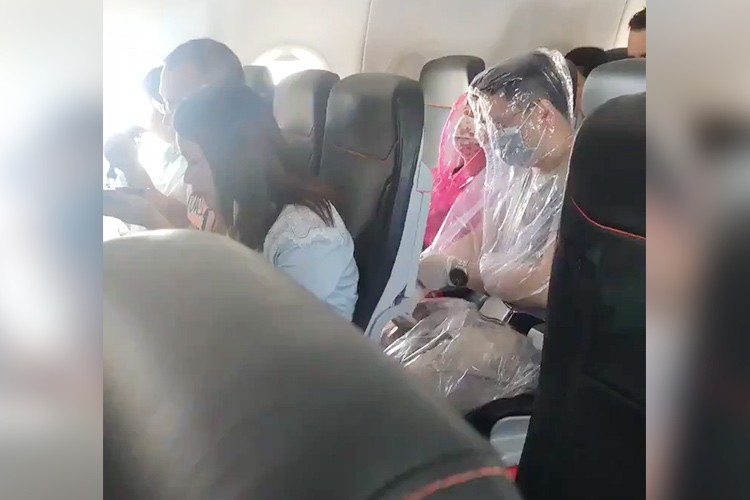 لتجنب الإصابة بفيروس كورونا.. ركاب الطائرات يغطون أنفسهم بالأكياس البلاستيكية